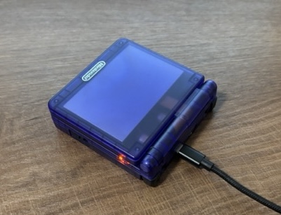 The same Nintendo Game Boy Advance SP as before, laying on the table, opened up.